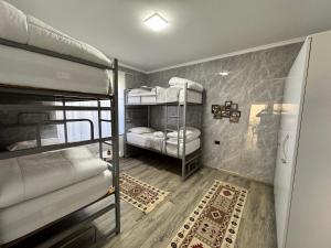 培拉特Hostel Leon Berat的带三张双层床和地毯的房间