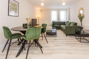 Una sala de estar con una mesa y sillas verdes. en Parsons House, en Washington