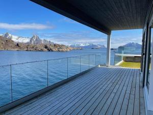 Un balcón de una casa con vista al agua. en Eksklusiv leilighet med spektakulær utsikt, en Kabelvåg