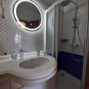 a bathroom with a sink and a shower and a mirror at ALKEA beachfront apartment Moles Kalives Halkidiki in Mola Kalyva