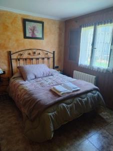 a bedroom with a bed with two towels on it at El Asturianu in Cangas de Onís