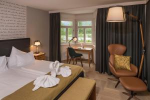 ein Hotelzimmer mit Bett, Stuhl und Schreibtisch in der Unterkunft G'sund & Natur Hotel Die Wasnerin - Adults Only in Bad Aussee + 65 Fotos