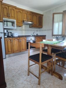 a kitchen with wooden cabinets and a table and chairs at El Asturianu in Cangas de Onís +8 photos