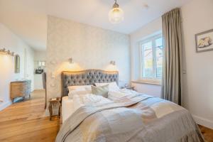 a bedroom with a large bed and a window at SCHLOSSBERG RESIDENCES - Betthupferl - Self Check-In Design Studios Aschaffenburg in Goldbach