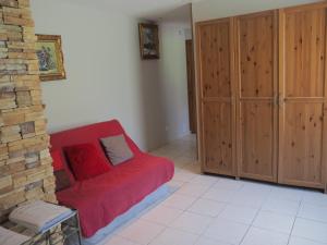 a living room with a red couch and wooden cabinets at Gite la Calabasse in Saint-Lary