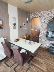 a table and chairs in a room with a stone wall at Das Häuschen in Taddigshörn in Bensersiel