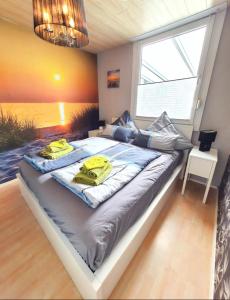 a bedroom with a large bed with yellow towels on it at Das Häuschen in Taddigshörn in Bensersiel