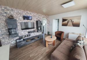 a living room with a couch and a stone wall at Das Häuschen in Taddigshörn in Bensersiel