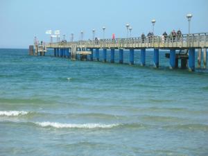 a pier in the ocean with people walking on it at Küstenwind in Graal-Müritz +1 photo