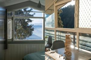a room with a table and a large window at Solisvista Stays in Mashobra