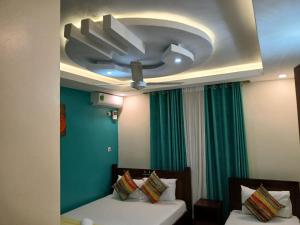 a bedroom with two beds and a ceiling fan at Nyali best pavil in Mombasa