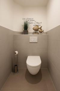 a bathroom with a toilet and a sign on the wall at Landhaus Chica in Salzgitter
