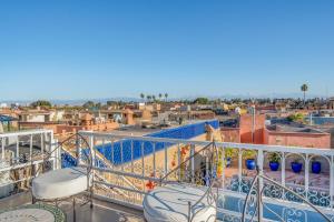 a balcony with chairs and a view of a city at RIAD AWINATI Location Privatisée , Piscine a jets, Petit déjeuner et magnifique Rooftop avec vue a 360 in Marrakesh