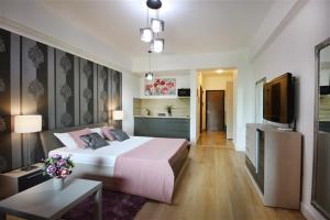 a bedroom with a large bed and a flat screen tv at Blue Bike Studio in Mamaia