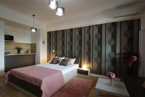 a bedroom with a large bed with a pink blanket at Blue Bike Studio in Mamaia
