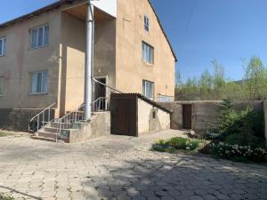a building with a door and a staircase in front of it at Jakesh in Karakol