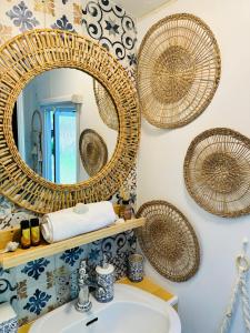 ein Badezimmer mit Spiegel und Rattankörben an der Wand in der Unterkunft Domek holenderski Hampton in Dominice