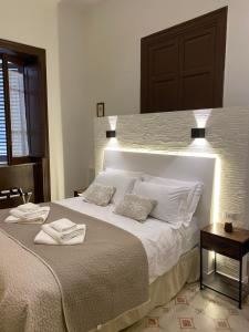 a bedroom with a large bed with two towels on it at Soste Normanne in Palermo