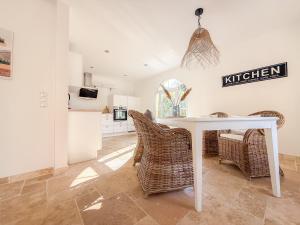 a kitchen with a white table and wicker chairs at Landhaus Chica in Salzgitter