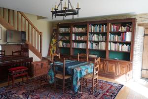 un comedor con una mesa y estanterías con libros en Les communs du manoir, en Loc-Maria-Plouzané