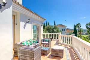 un patio con muebles de mimbre en el balcón en Casa Lorraine, en Mijas