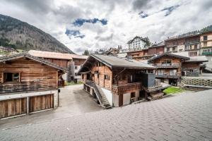 a group of wooden buildings with mountains in the background at Janin 3 Charmant appartement rénové avec 2 chambres et espace cabine in Morzine