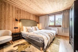 a bedroom with a bed and a chair and a window at Janin 3 Charmant appartement rénové avec 2 chambres et espace cabine in Morzine