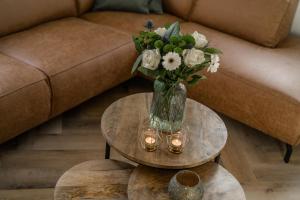 a vase of flowers on a table with candles at De Dommelhoeve in Peer