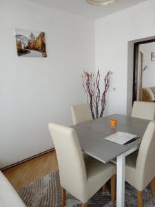 a dining room with a table and white chairs at Stan na dan Miki -M Teslic in Teslić