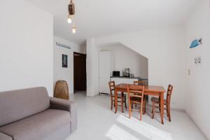 a living room with a table and chairs and a couch at A_mare San Vito Lo Capo in San Vito lo Capo