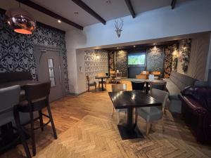 a living room with a table and chairs and a couch at Richmond Park Hotel in Boʼness
