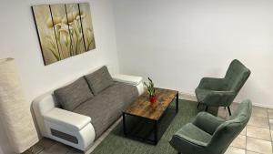 a living room with a couch and two chairs at Gästehaus Ferienwohnung Wohnung #3 in Jülich