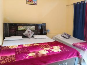two beds in a room with a purple bedspread at Om som home stay hill view in Jāmb