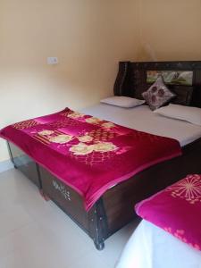 a large bed with a pink blanket on it at Om som home stay hill view in Jāmb