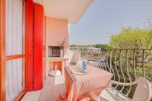 Un balcón con una mesa y sillas en un balcón. en Residence Le Ginestre Mare, en Cavallino-Treporti
