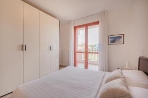 Una habitación blanca con una cama y una ventana en Residence Le Ginestre Mare, en Cavallino-Treporti