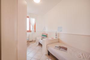 Habitación blanca con 2 camas y mesa en Residence Le Ginestre Mare, en Cavallino-Treporti 5 fotos más