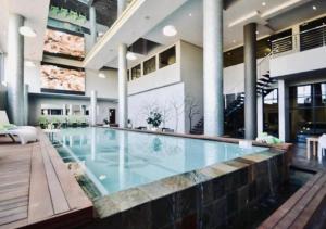 a large swimming pool in a building at Cosy Urban Apartment in Durban