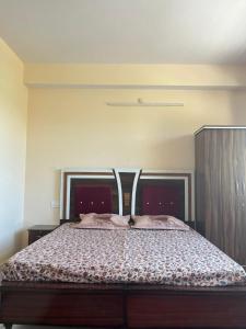 a bedroom with a large bed with a wooden headboard at Nature View Home Stay in Kīar