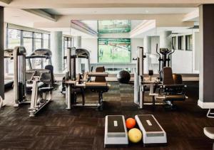 a gym with several treadmills and exercise machines at Cosy Urban Apartment in Durban