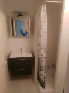 een badkamer met een wastafel en een spiegel bij Les Appartements De Lina - Trianon 38 - Self Check-In - in La Grande-Motte