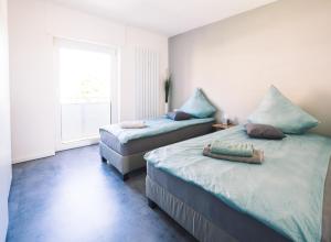 une chambre avec deux lits et une fenêtre dans l'établissement Vintage Apartment Schwetzingen - 2 Zimmer - Küche, Bad & Balkon, à Schwetzingen