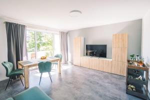 un salon avec une table et une télévision dans l'établissement Vintage Apartment Schwetzingen - 2 Zimmer - Küche, Bad & Balkon, à Schwetzingen