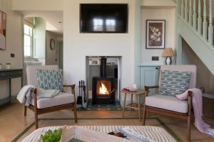 een woonkamer met twee stoelen en een open haard bij Montagu in Thornhill