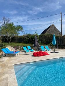 a swimming pool with chairs and umbrellas and a group ofatoes at Magnone Vacance - Gîte Belle Vue in Lavercantière