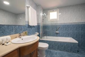a bathroom with a sink and a toilet and a tub at Macdonald Doña Lola Resort in La Cala de Mijas