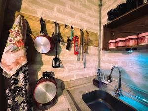 a kitchen with utensils hanging on a wall at Refugio Jabuticaba, CASA DA MATA - Você imerso na mata atlântica in Santo Antônio do Pinhal +23 photos