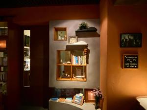 a room with a shelf with books and a clock at The Deer Head Inn in Kenting