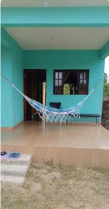 a hammock in front of a blue house at Casa Soul de Verão in Ilha Comprida