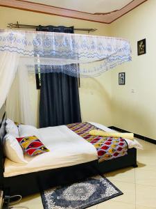 a bedroom with a bed with a canopy and a window at Kararan homes in Kapchorwa
